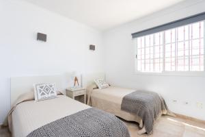 twee bedden in een witte kamer met een raam bij Villa Chloe Costa Adeje Tenerifesummervillas GIANT PRIVATE POOL 11 METERS LONG in Adeje +41 foto's