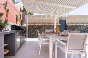 een witte tafel en stoelen op een patio bij Villa Chloe Costa Adeje Tenerifesummervillas GIANT PRIVATE POOL 11 METERS LONG in Adeje