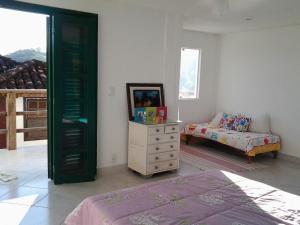 a bedroom with a bed and a dresser and a couch at Casa Angra Itanema in Angra dos Reis +30 photos