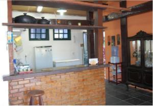 a kitchen with a brick counter with pots and pans at Casa Angra Itanema in Angra dos Reis