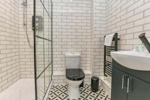 a bathroom with a toilet and a sink and a shower at Peaceful Urban Getaway in Liverpool