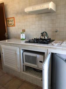 a kitchen with a stove and a microwave at Attici Agli Acquedotti Romani in Rome