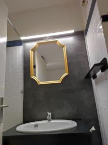 baño con lavabo y espejo en la pared en APPARTEMENT HOURTIN PLAGE ET PORT en Hourtin