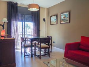 ein Wohnzimmer mit einem Tisch, Stühlen und einem roten Sofa in der Unterkunft Tarragona Ciudad, El Serrallo AP-1 in Tarragona