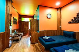 sypialnia z 2 łóżkami i zegarem na ścianie w obiekcie ชานไม้ รีสอร์ท 