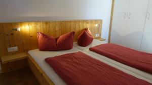 1 Schlafzimmer mit 2 Betten und roten Kissen in der Unterkunft Rossweid Huette in Stans