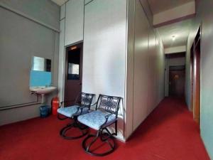 a hallway with two chairs and a sink in a room at Rz Gold Hotel Official Account in Kuala Kerai