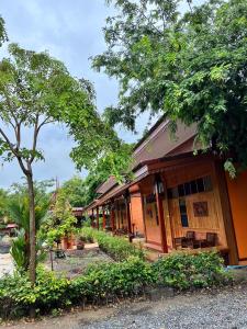 un edificio con un árbol delante de él en ชานไม้ รีสอร์ท 