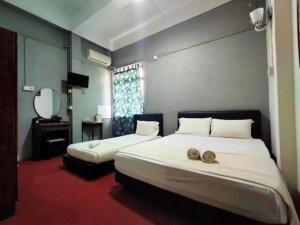 a bedroom with two beds and a mirror at Rz Gold Hotel Official Account in Kuala Kerai