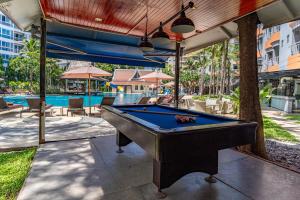 una mesa de billar en un patio junto a una piscina en Heeton Concept Hotel Pattaya by Compass Hospitality, en Pattaya central