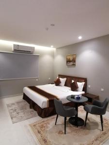 una camera con letto, tavolo e sedie di المواسم الأربعة للوحدات السكنية a Tabuk