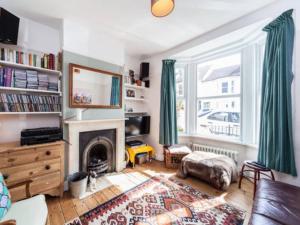a living room with a fireplace and a large window at Three Bedroomed Victorian Family House, Garden in Brighton & Hove