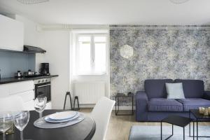 a living room with a purple couch and a table at Villa Pax 1 et 2 La Bourboule in La Bourboule