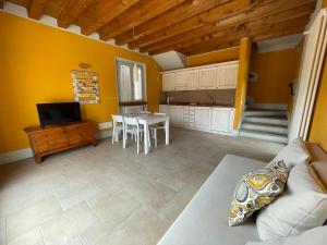 a living room with a table and a kitchen at Le Casette di Olga -Space for Nature and Sport Lovers- in Baone
