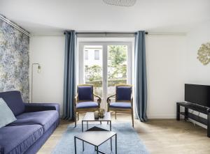 a living room with a blue couch and two chairs at Villa Pax 1 et 2 La Bourboule in La Bourboule