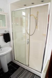 a glass shower in a bathroom with a sink at Number 19 Heart Of The Glens in Cushendall