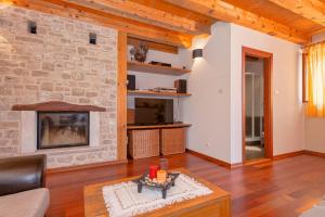 a living room with a fireplace and a stone wall at Holiday Home Rudina in Stari Grad