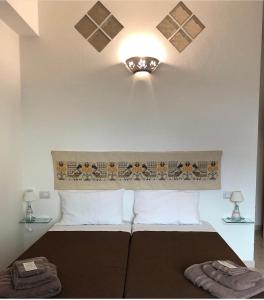 1 dormitorio con 1 cama y una luz en el techo en B&B Sa Clarera, en Baunei