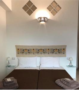 a bedroom with a bed and a light on the ceiling at B&B Sa Clarera in Baunei