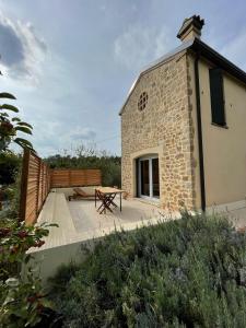 a stone building with a patio and a picnic table at Le Casette di Olga -Space for Nature and Sport Lovers- in Baone