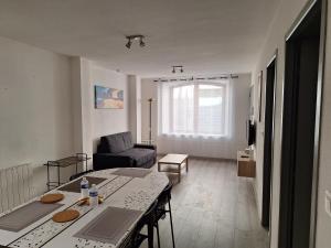 a living room with a table and a couch at Au cœur de Caillassou in Villemur-sur-Tarn