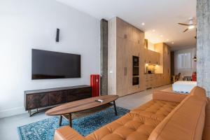 Una sala de estar con un sofá y un televisor. en VR Palace Apartments, en Madrid
