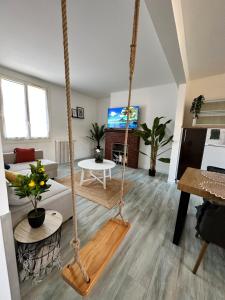 una sala de estar con un columpio en una habitación en Le Calme en Hyper-Centre, en Pont-lʼÉvêque