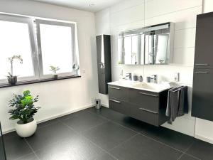 Baño blanco con lavabo y espejo en Penthousewohnung direkt am Wald, en Nalbach