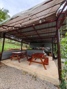 two picnic tables under a wooden pergola at Elnora's Farm in Lucban