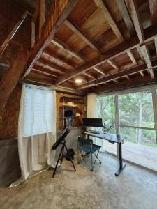 a room with a piano and a desk in a house at Elnora's Farm in Lucban