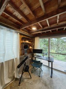 a room with a piano and a desk in a house at Elnora's Farm in Lucban