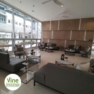 un vestíbulo con sofás y mesas en un edificio en Vine Residences Staycation en Manila