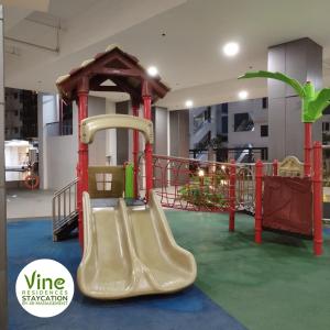 einen Spielplatz mit Rutsche in einem Gebäude in der Unterkunft Vine Residences Staycation in Manila