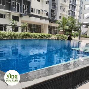una gran piscina azul frente a un edificio en Vine Residences Staycation en Manila