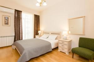 Un dormitorio con una cama y una silla verde. en Cozy Apartment In The City Center, en Tiflis
