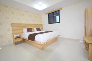 una camera con un grande letto e una finestra di Hotel Midnight a Ahmedabad