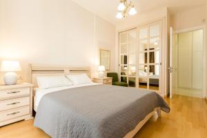 Un dormitorio blanco con una cama grande y una silla. en Cozy Apartment In The City Center, en Tiflis