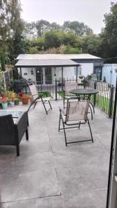 a patio with three chairs and a table and tables at ACCOMADATION WREXHAM in Wrexham