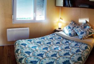 Un dormitorio con una cama con sábanas azules y blancas y una ventana en Au Temps Suspendu - 3 chambres - Au coeur de la nature - À 10 minutes des commerces, en Vielle-Tursan