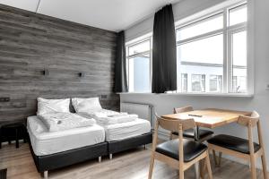 a bedroom with a bed and a desk and a table at Stay Apartments Bolholt in Reykjavík