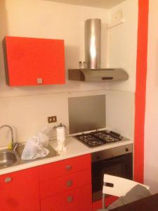 雷焦艾米利亞的住宿－punto G，厨房配有红色橱柜和炉灶烤箱