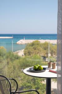 a table with a plate of fruit on it with a view of the ocean at Erato by Samian Mare in Karlovasi