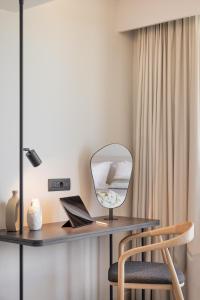 a desk with a mirror and a chair in a room at Erato by Samian Mare in Karlovasi