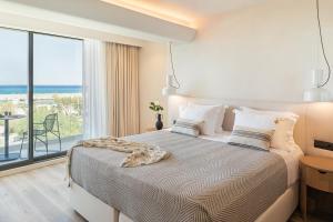 a bedroom with a large bed with a large window at Erato by Samian Mare in Karlovasi