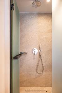 a shower with a shower head in a bathroom at Erato by Samian Mare in Karlovasi