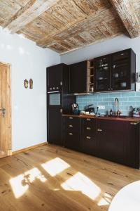 a kitchen with black cabinets and a wooden floor at Flecksches Gut in Leipzig