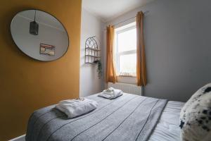 a bedroom with two towels on a bed with a mirror at Oldfield Apartments - Bath in Bath