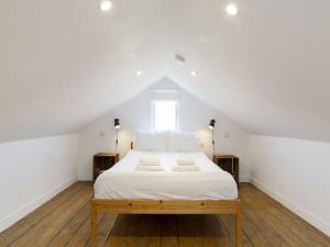 a bedroom with a bed with white sheets and a window at Pass the Keys 19th Century Barn with Free Parking in Histon