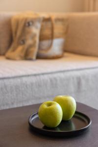 two green apples on a plate on a table at Erato by Samian Mare in Karlovasi