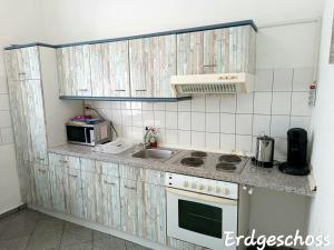 uma pequena cozinha com um fogão e um lavatório em APARTMENT MONTEURZiMMER AM BAHNSTEIG em Kuppenheim